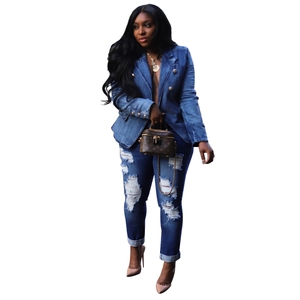Close-up of slim fit denim blazer with embossed gold lion buttons and ripped jeans