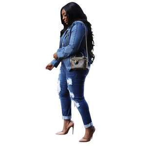 Close-up of distressed denim jacket with lion buttons and ripped jeans with rolled cuffs