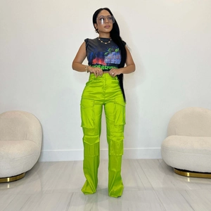 Détail du pantalon cargo vert fluo avec finition satinée et poches utilitaires
