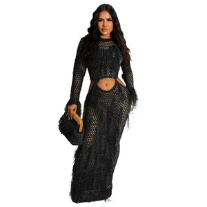 Close-up of black hollow-out crochet beach dress featuring long sleeves and tassel details