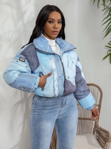 Close-up of patchwork denim puffer jacket with stand collar and zipper detail