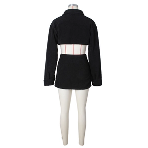 Detail of black faux shearling fleece two-piece set featuring short jacket and mini skirt
