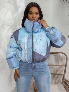 Detail of a vintage denim patchwork jacket featuring a high collar and metal zipper closure