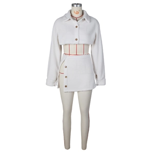 Detail view of white fleece two-piece set featuring cropped buttoned top and slit mini skirt