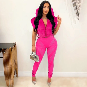 Dettaglio del gilet con cappuccio in ecopelliccia rosa e pantaloni a vita alta coordinati