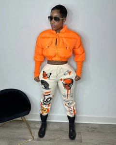 Detail of bright orange puffer jacket with stand collar and white graphic print joggers