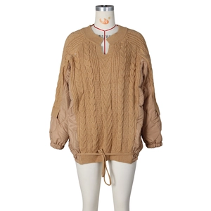 Detail view of khaki patchwork sweater with cable knit pattern and quilted texture