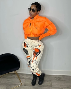 Close-up of winter cropped orange puffer jacket with high collar and streetwear joggers