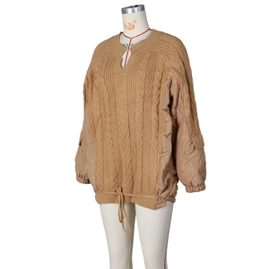 Detail of cable knit and diamond quilted puffer jacket with adjustable drawstring hem