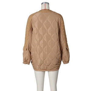 Detail view of khaki quilted jacket with textured cable knit sleeves and ribbed cuffs