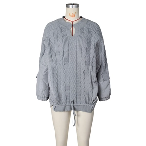 Detail of grey cable knit bodice with quilted sleeves and adjustable drawstring hemline