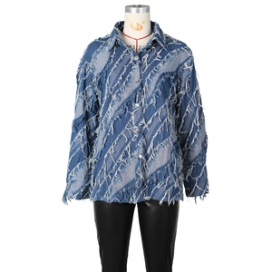 Détail d'une veste en jean avec franges diagonales et boutons métalliques