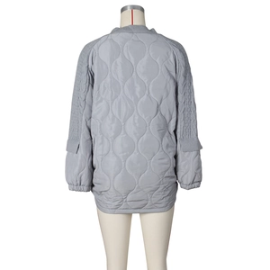 Detail view of the back showing cable knit sleeves and quilted fabric on grey jacket
