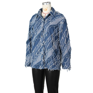 Gros plan détaillé des franges en denim diagonales sur une veste décontractée bleue