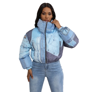Detail shot of a women's short puffer jacket with blue denim print and high stand collar