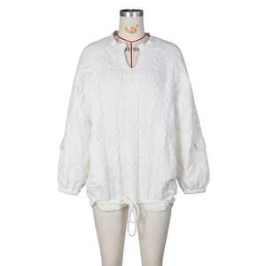 Detail view of white quilted oversized jacket with knit panels and drawstring hem