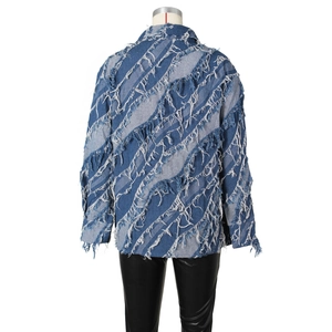 Détail d'une veste en jean avec motifs floraux à franges et bords effilochés au dos