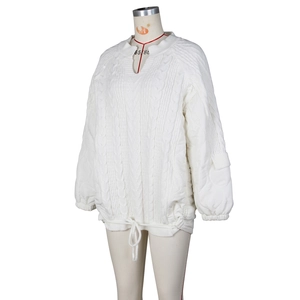 Detail of cable knit and quilted fabric texture with adjustable drawstring hem