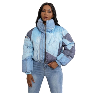 Detail of denim print puffer jacket showing contrast panels and rib-knit elastic hem