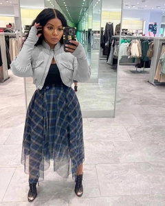 Detail of grey cropped puffer jacket with stand collar and plaid mesh midi skirt set