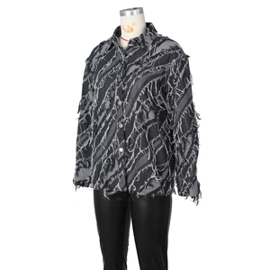 Détail de la veste en jean gris foncé délavée avec franges et textures déchirées usées