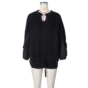 Detail of cable knit texture and quilted sleeve stitching on casual black jacket