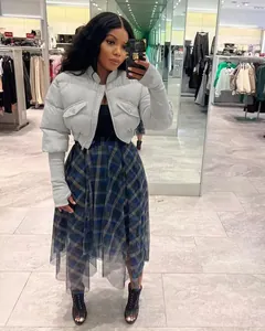 Detail of short grey puffer jacket with ribbed knit sleeves and plaid mesh midi skirt