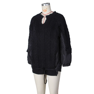 Detail of cable knit texture and quilted sleeve patchwork on black winter jacket