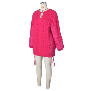 Detail of hot pink cable-knit sweater with quilted sleeves and side drawstring ties