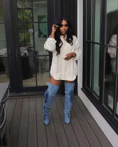 Detail of white oversized drawstring sweater and denim thigh-high cargo boots outdoor