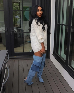 Detail of light blue denim thigh-high boots with cargo pockets and stiletto heels