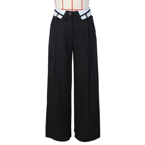 Dettaglio dei pantaloni neri a gamba larga a vita alta con design a risvolto bianco in vita