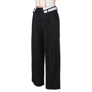 Dettaglio dei pantaloni ampi eleganti a vita alta con risvolto bianco a contrasto unico