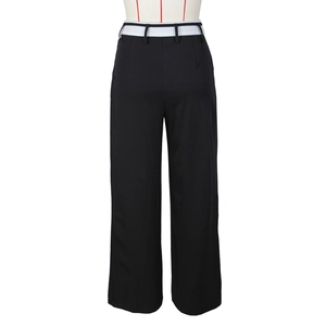 Dettaglio dei pantaloni neri a gamba larga con vita a contrasto bianca elegante