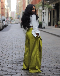 Detail of olive green silk wide-leg trousers with high waist and elegant vertical drape
