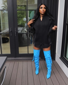 Detail of cable knit black sweater and bright blue leather thigh high boots with pockets