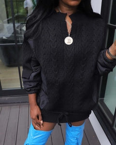 Detail of black patchwork knit coat with gold necklace and blue over-knee boots