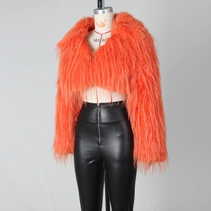 Detail einer flauschigen orangefarbenen Webpelzjacke mit schwarzer Kunstleder-Reißverschlusshose