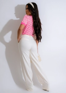 Detail of pink heart jacquard knit top paired with white wide-leg trousers
