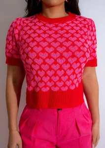 Close-up of heart jacquard pattern on women's knit short sleeve top with red ribbed edges