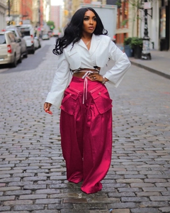 Detail view of pink high-waisted wide-leg cargo pants with large side pockets and silk texture