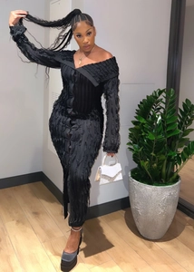 Detail of off-shoulder black bodycon dress with textured wavy fabric and long sleeves