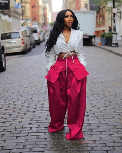 Detail shot of oversized functional cargo pockets on stylish magenta wide-leg trousers