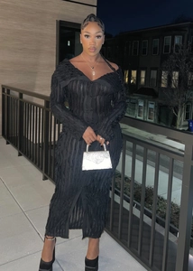 Detail of black off-shoulder maxi dress featuring textured fabric and buttoned front