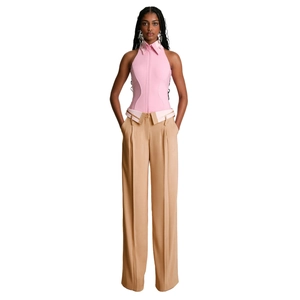 Dettaglio di pantaloni kaki a gamba larga a vita alta con una camicia rosa a girocollo