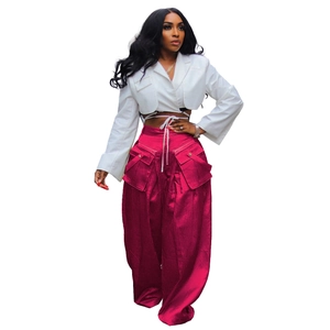 Detail of fuchsia cargo wide-leg pants with large flap pockets and satin finish fabric