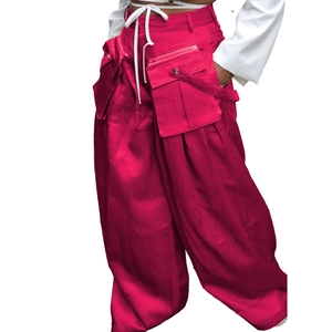 Detail of magenta cargo pants with large 3D pockets and white drawstring waist cord