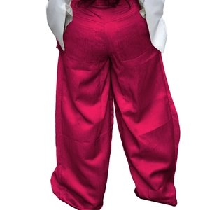 Detail view of the back of rose pink wide-leg trousers with vertical texture and pocket