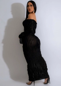 Detail of black off-shoulder dress with vertical stripes and ruffled lettuce edge trim
