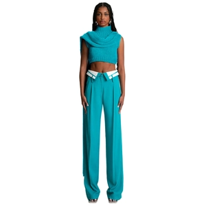 Dettaglio dei pantaloni larghi turchesi con esclusivo design della vita risvoltata bianca